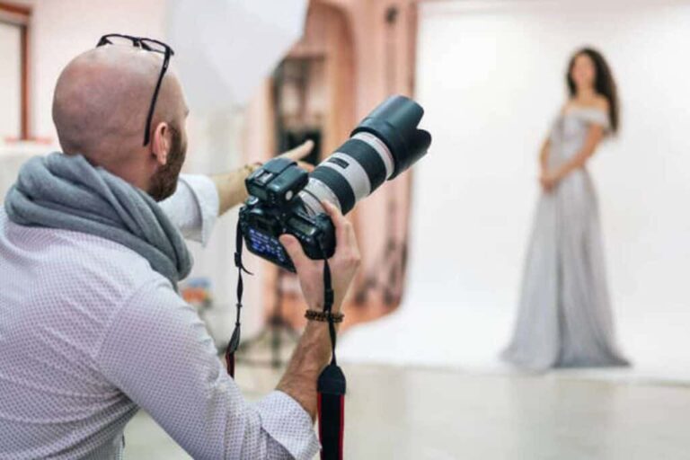 Fashion photographer shooting a photo session with a model in a studio