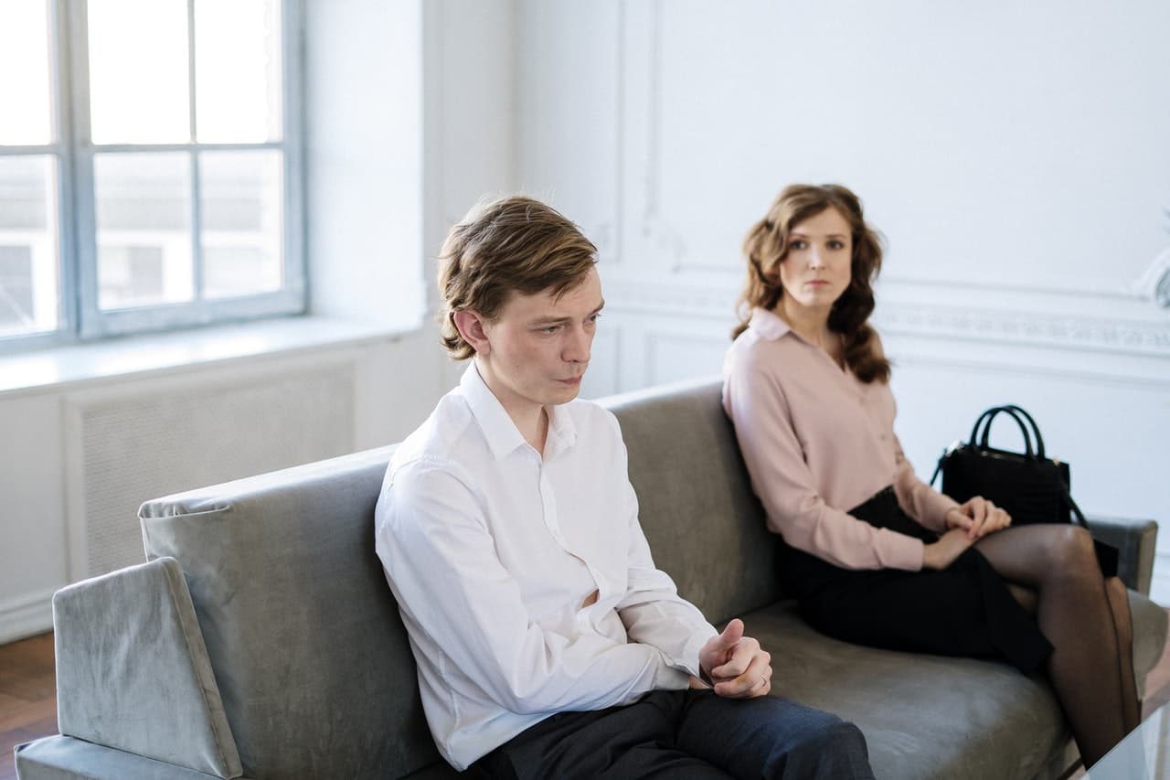 Couple sitting on couch and aruging about erectile dysfunction treatment